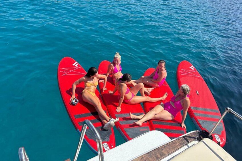 A group of people on a red paddleboard in the water. 3