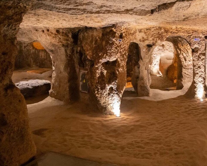 A cave with stalactites and stalagmites, illuminated by artificial lighting. 4