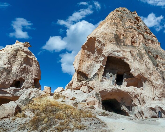 A rock formation with caves and a clear blue sky. 2