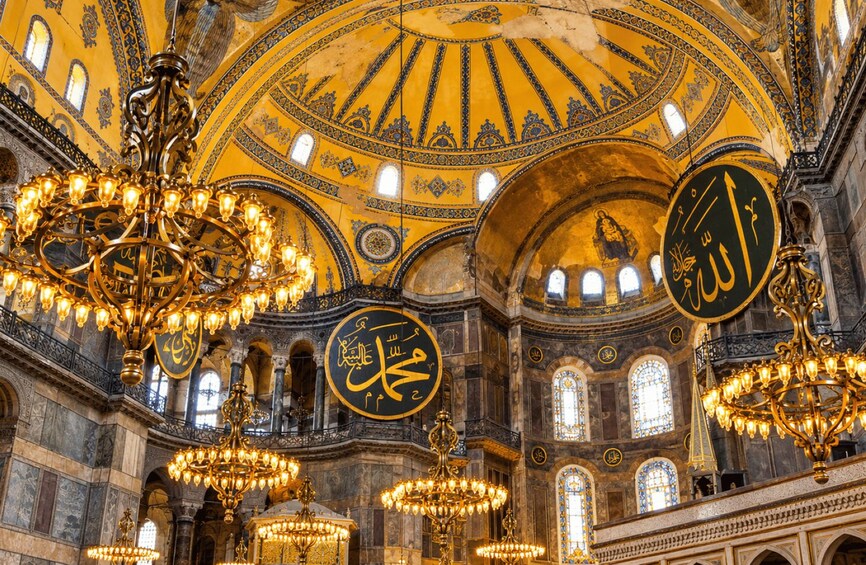 A grand interior with ornate chandeliers, golden domes, and intricate wall carvings. 2