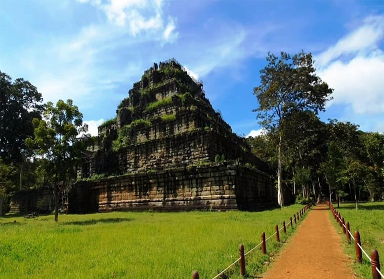 A large ancient stone structure surrounded by lush greenery and a clear sky. 4