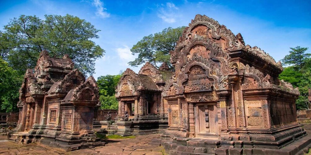 Ancient stone structures with intricate carvings and a clear blue sky. 2