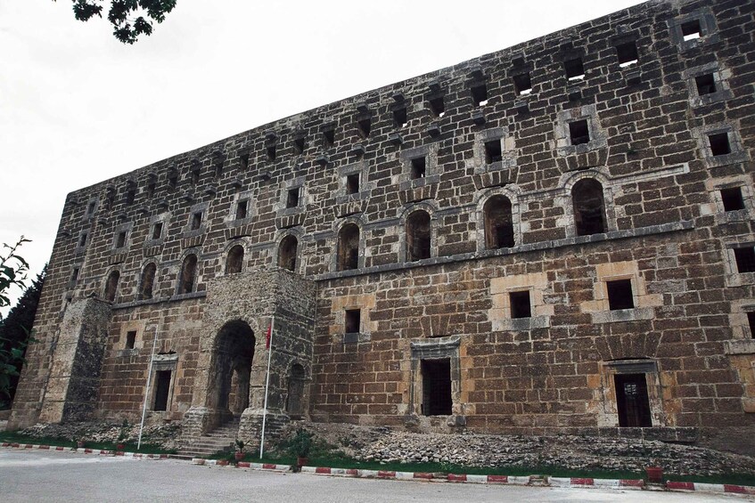 An ancient stone building with arched windows and a central entrance. 4