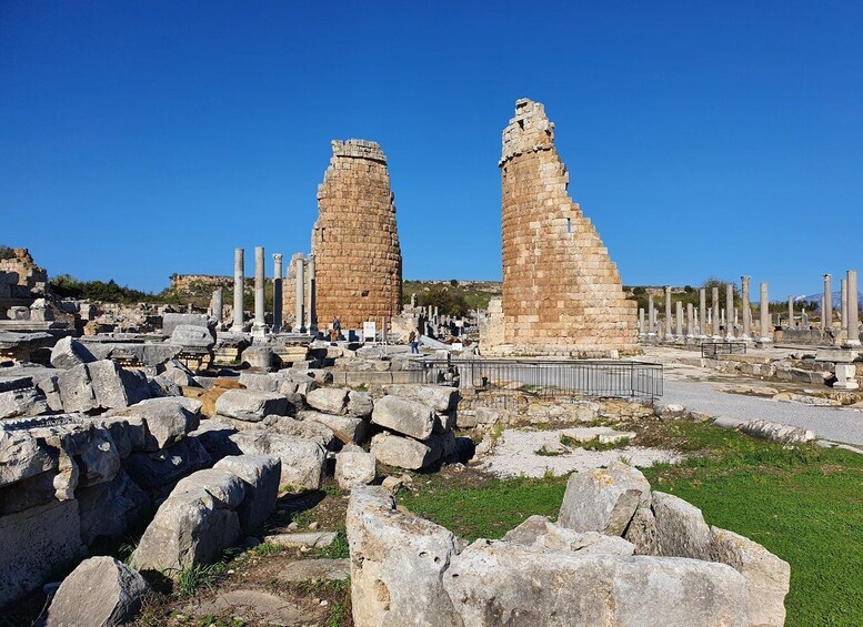 Ancient ruins with stone columns and two prominent stone towers. 1