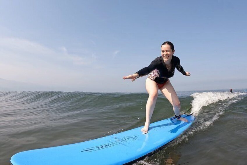 A person surfing on a blue board in the ocean. 5