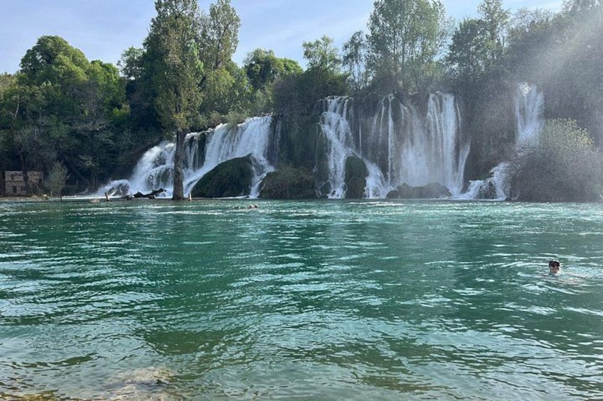 A waterfall cascading over rocks into a river surrounded by trees. 4