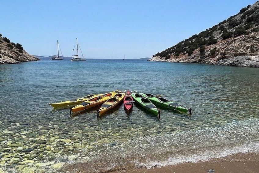 Un mar tranquilo con kayaks y veleros. 3