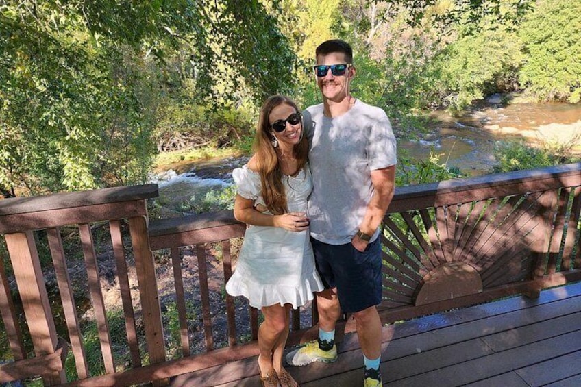 A wooden bridge with a railing, surrounded by greenery and a river. 5