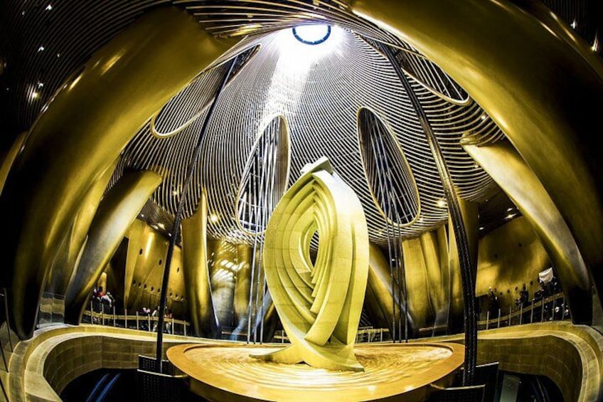 A modern architectural structure with a central spiral design and golden elements. 2