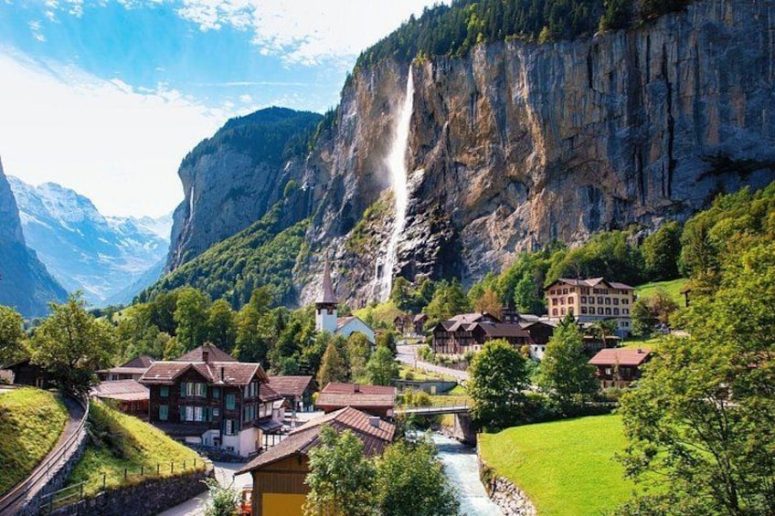 Un pueblo montañoso con casas, un río y una cascada. 4