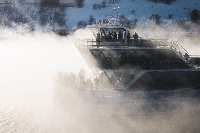 Un bateau avec des personnes à bord, entouré de brume. 1