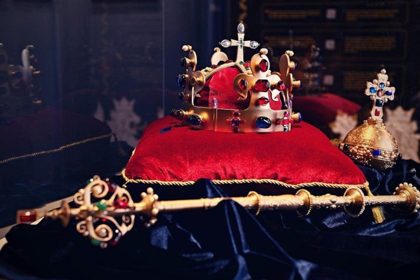 Een rijk versierde koninklijke troon met een rode kussen, een versierd gouden scepter en een kroon. 3