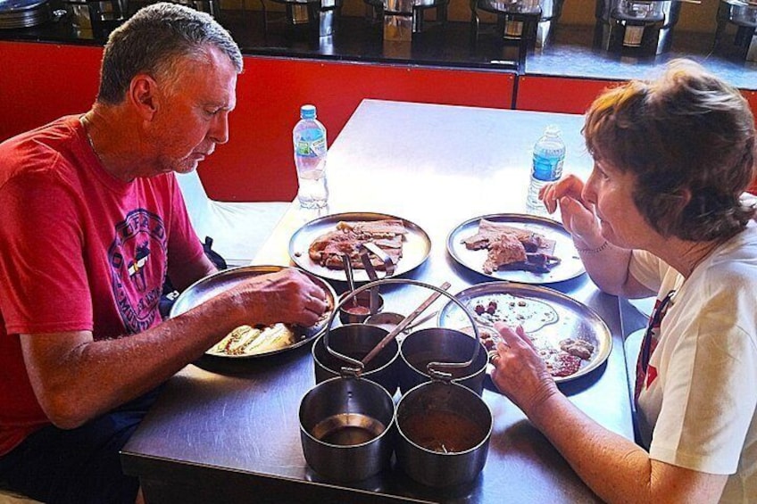 Two people dining at a restaurant with plates of food and drinks. 2