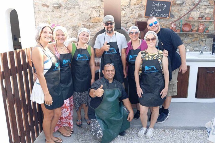 A group of people wearing aprons in front of a bakery. 3