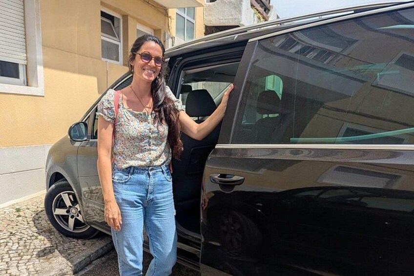Una persona in piedi accanto a un veicolo, con un edificio sullo sfondo. 5