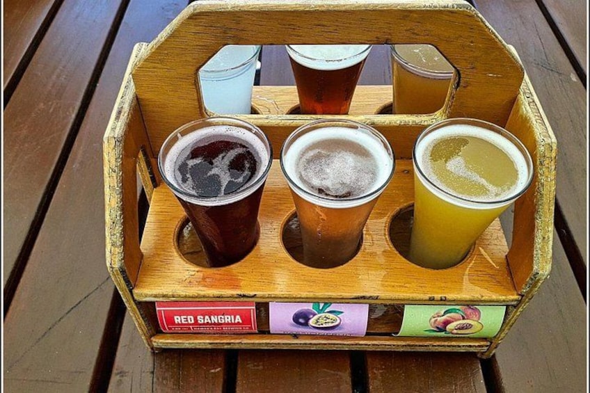 Una cassa di legno con sei bicchieri di birra, ognuno etichettato con un frutto diverso. 5