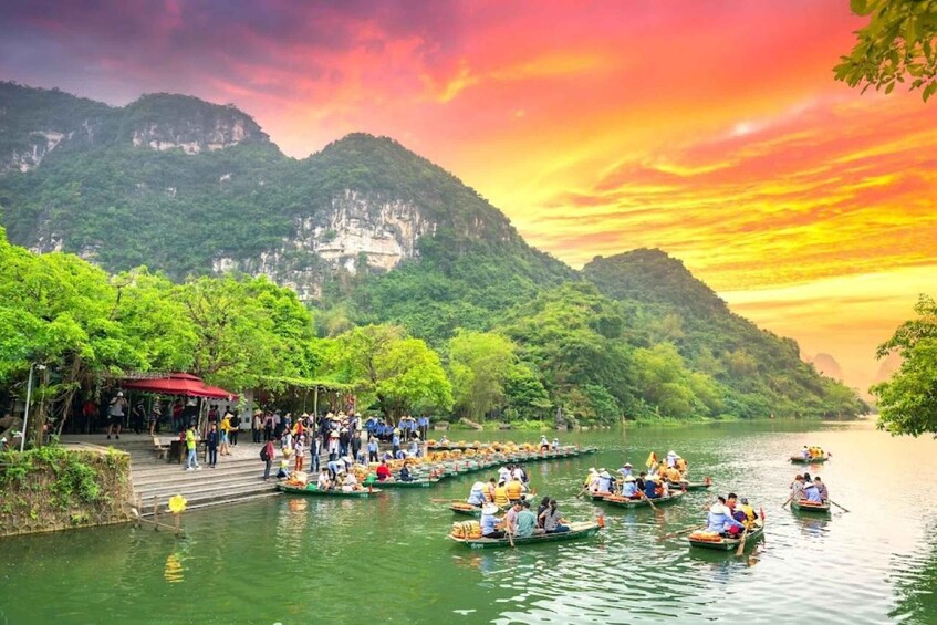 A group of people in boats on a river, surrounded by lush greenery and mountains. 2