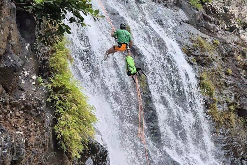 Une personne qui descend une cascade en rappel. 1