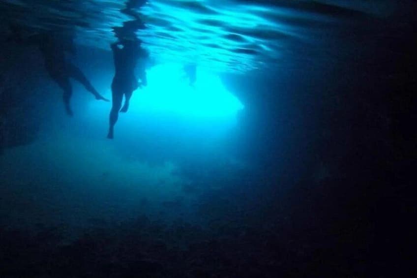 Une personne nageant sous l’eau avec une source de lumière bleue. 4
