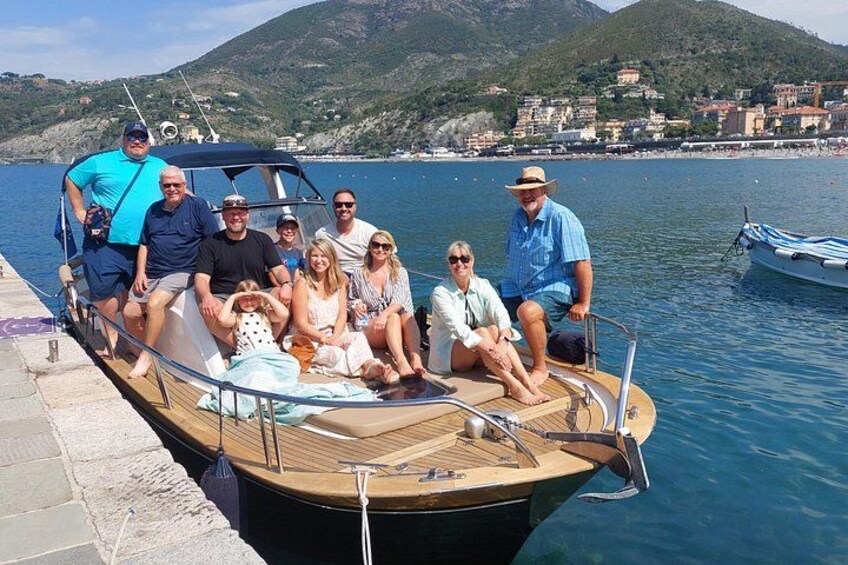 A group of people on a boat docked at a pier with a mountainous landscape in the background. 2