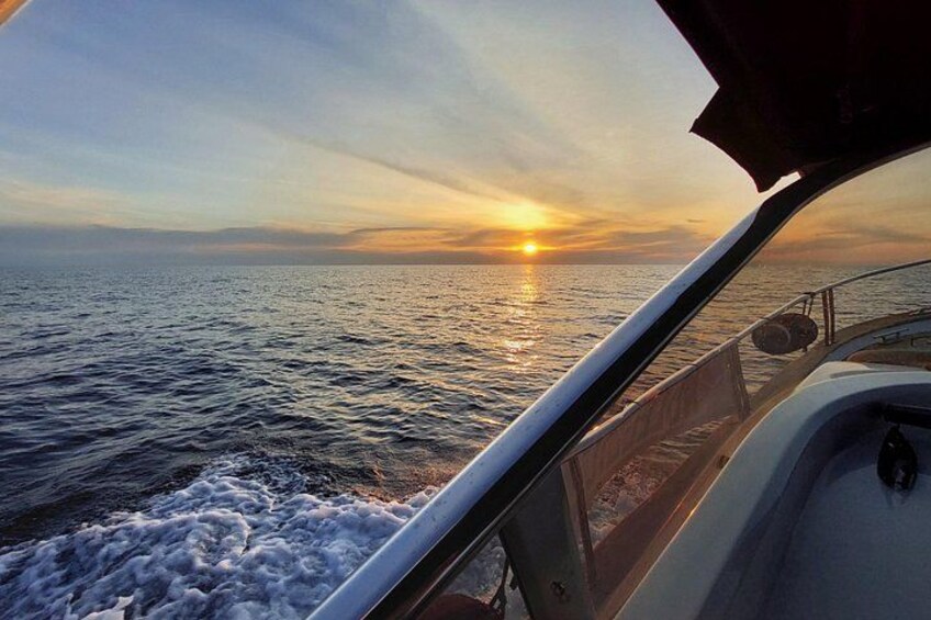 A boat on the water with a sunset in the background. 5