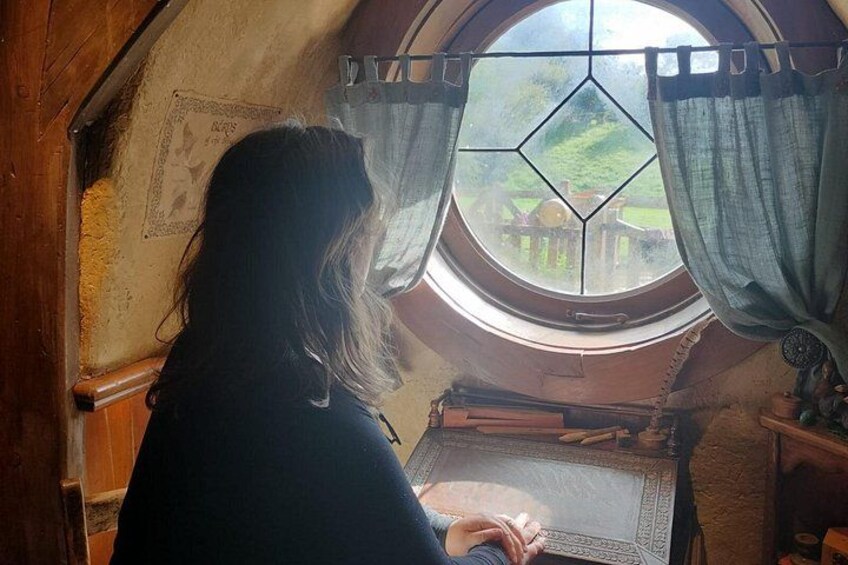 A person sitting by a window with a view of a garden. 2