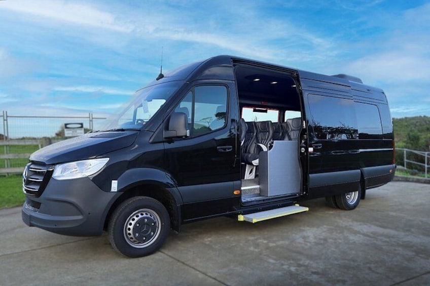 A black van with an open door, revealing a cargo area with a step leading down to the ground. 5