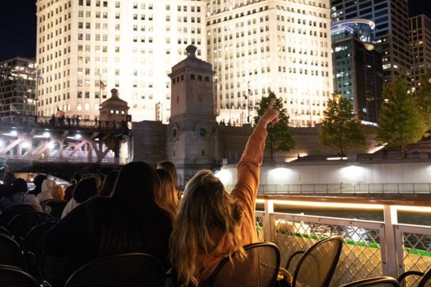 Una persona señalando un edificio de noche. 2