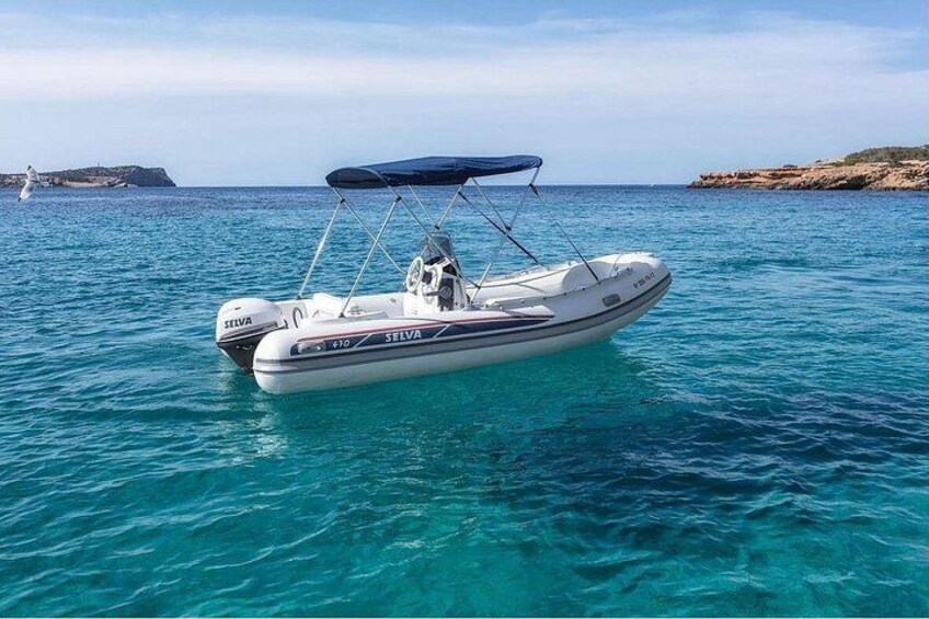 A white motorboat with a canopy on a calm sea. 4
