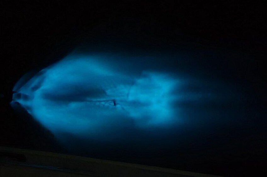 A blue light illuminating a structure, possibly a boat or ship, with a dark background. 4