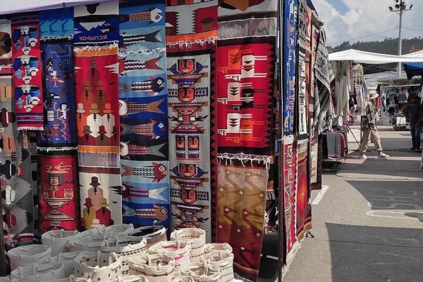 Un mercado callejero con textiles y cestas de colores. 2