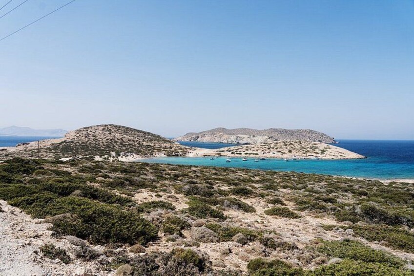 A coastal landscape with rocky terrain and a clear blue sea. 3