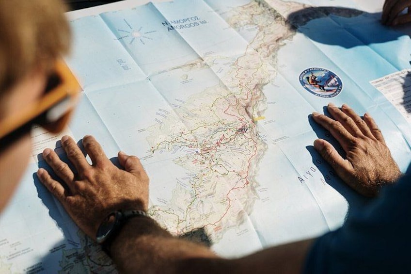 A person examining a map with a compass rose and a logo. 2