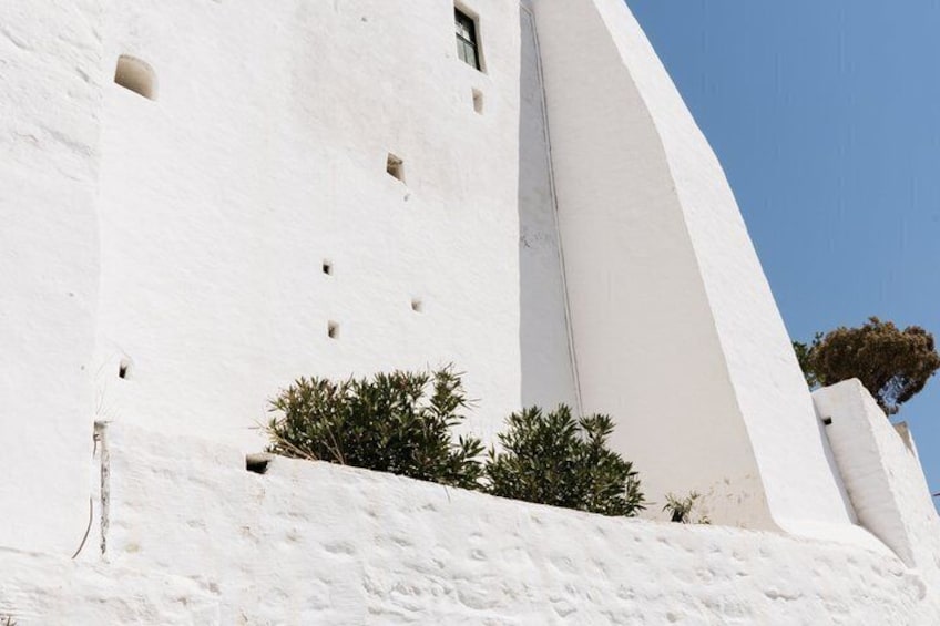 Un bâtiment blanc avec des fenêtres en arc et un arbre. 3