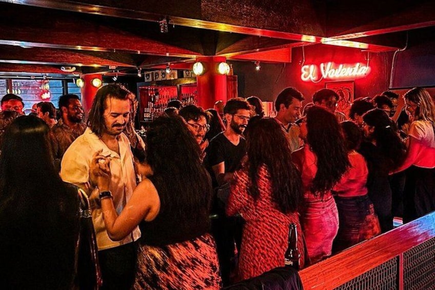 Een drukke bar vol mensen die dansen en gezellig samenzijn. 3