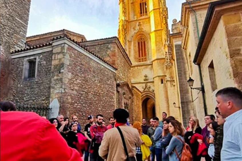 A crowd of people gathered in front of a historic building with a prominent tower. 2