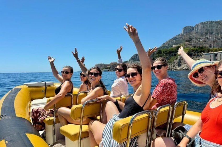 People on a yellow inflatable boat with rocky cliffs in the background. 1