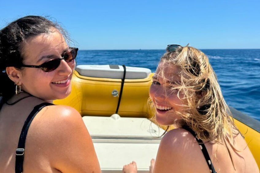 Two people on a yellow boat with the ocean in the background. 2