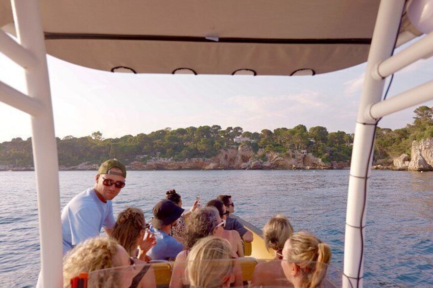A group of people on a boat with a rocky coastline in the background. 3