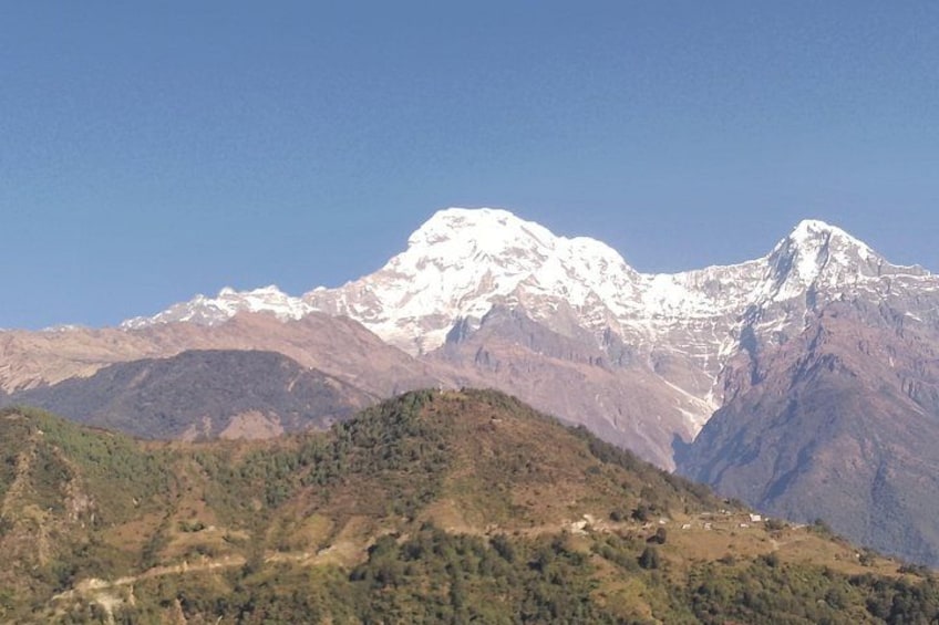 Une chaîne de montagnes aux sommets enneigés, avec des collines verdoyantes au premier plan. 5