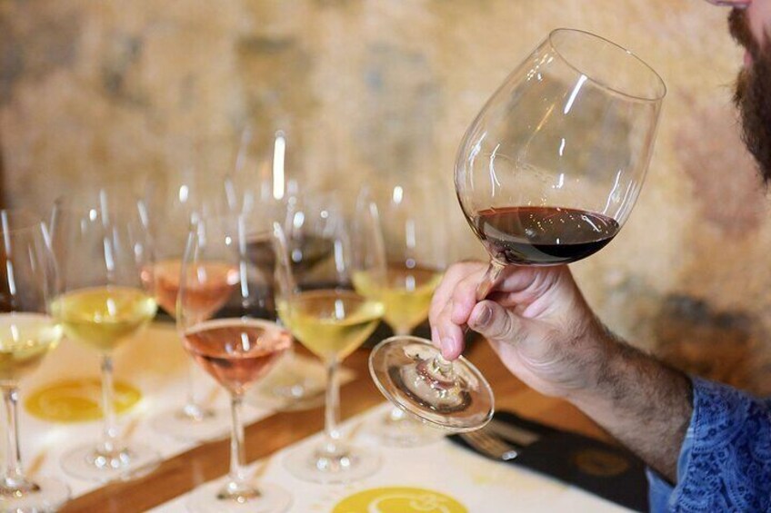 A person holding a wine glass with a wine bottle. 1