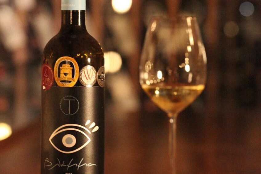 A bottle of wine with a label featuring an eye symbol and a glass of wine. 4