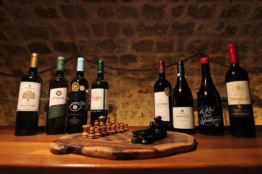 A wooden table with wine bottles and a chessboard. 5