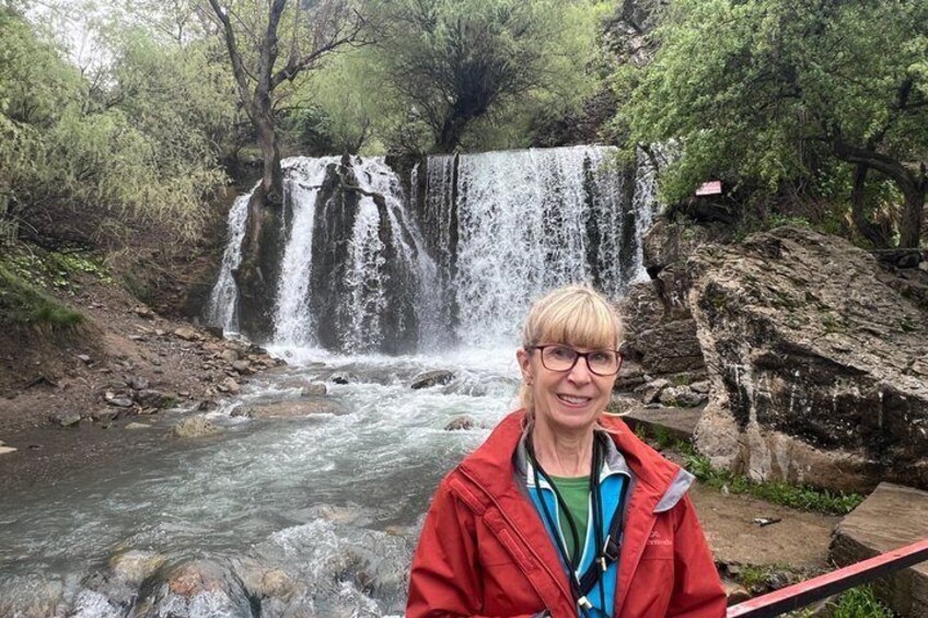 A waterfall, a river, and a person in a red jacket. 5