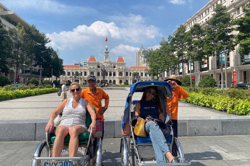 A group of people in wheelchairs and a wheelchair in a public square with buildings in the background. 4