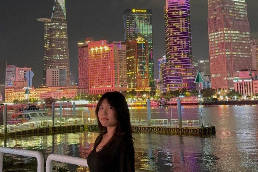A nighttime cityscape with illuminated buildings and a body of water. 1