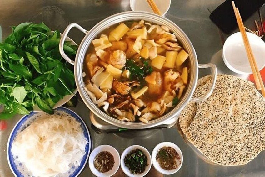 A hot pot with various ingredients, a bowl of noodles, and a plate of flatbread. 3