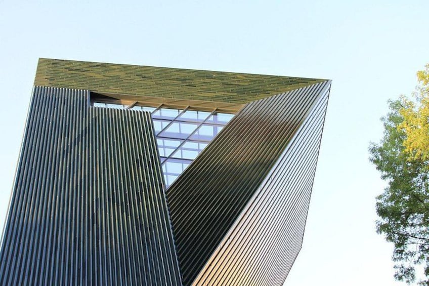 A modern building with a unique angular design, featuring a mix of vertical and horizontal lines. 4