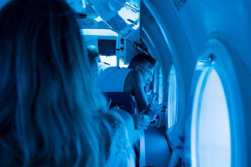 A person sitting by an airplane window, looking out. 1
