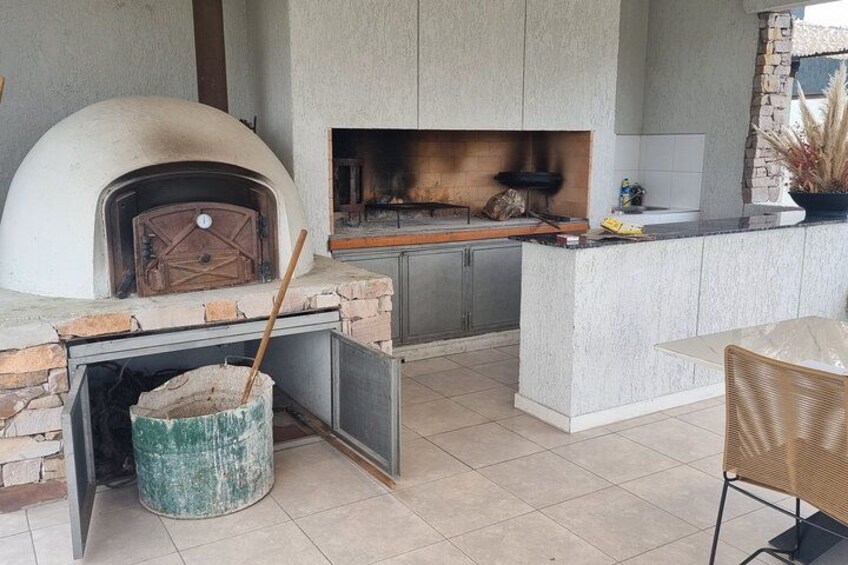 A kitchen with a stone oven, a fireplace, and a dining area. 4